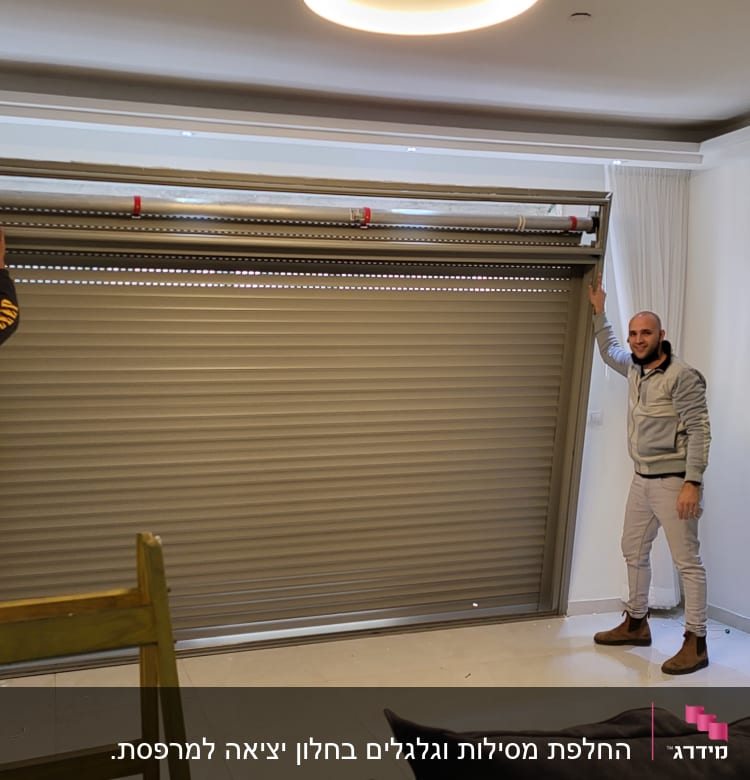 שני אנשים מתקינים תריס אלומיניום בחדר